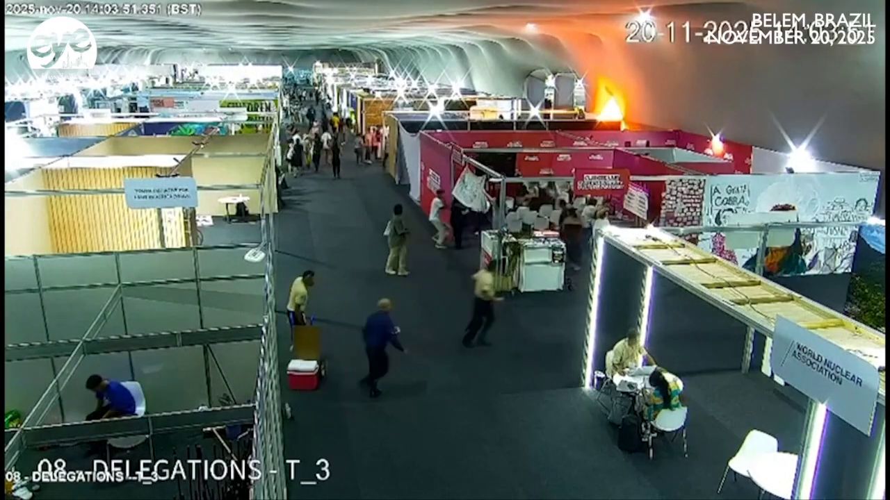 Exhibition hall camera view with a fire starting behind a booth